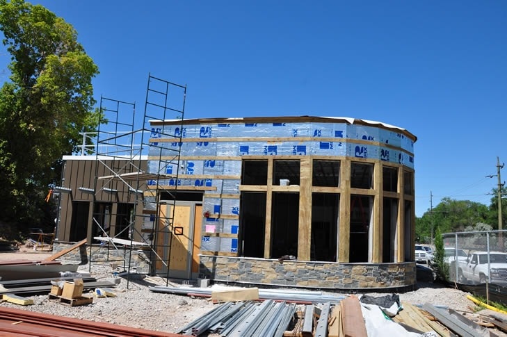 New construction building under scaffolding — framing and sheathing